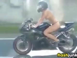 З оголеними грудьми татуювання ціпонька скаче a motorcycle
